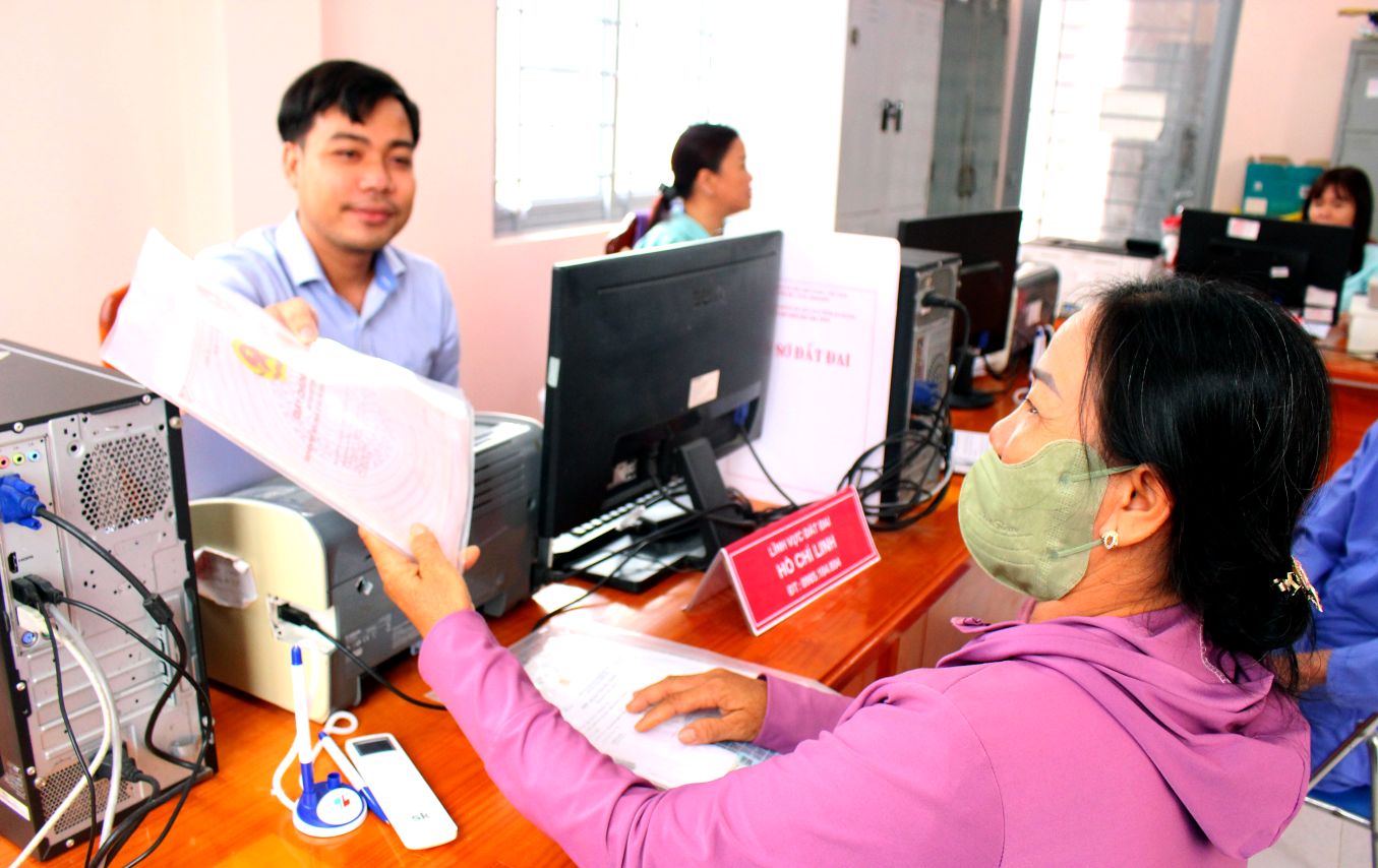 Nguoi dan tuoi tan khi nhan ho so tu tay can bo phu trach linh vuc dat dai ngay tai Trung tam Phuc vu hanh chinh cong xa Ba Chuc voi thai do an can. Anh: Thanh Mai 