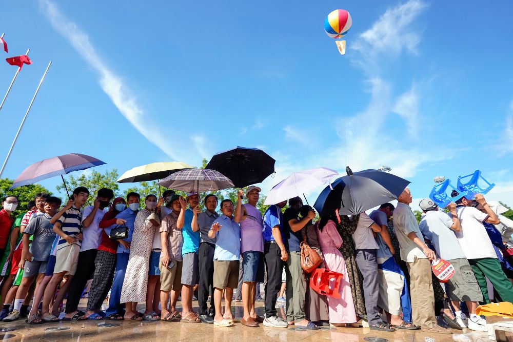 팬들이 VTV 컵 2025 배구 결승전 티켓을 사려고 햇볕 아래 줄을 서서 기다리고 있습니다. 사진: 타이카