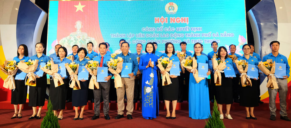 La Sra. Phan Thi Thuy Linh - Presidenta de la Federacion Laboral de la Ciudad de Da Nang (Medio), dio flores para felicitar al Presidente del sindicato de 24 NUEVOS WARDS. Foto: Tuong Minh