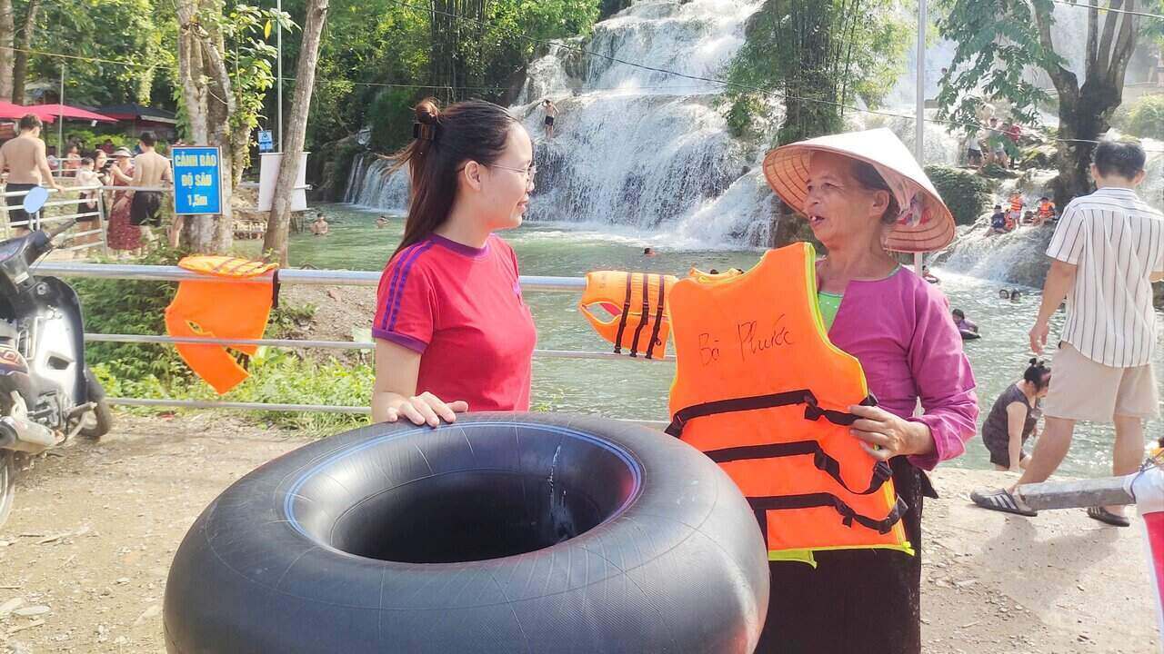 Ba con nguoi Muong sinh song o khu vuc thac Trang bat dau tap lam du lich, don gian nhu cho thue ao phao, voi gia 10 nghin dong/luot thue. Anh: Binh Khang