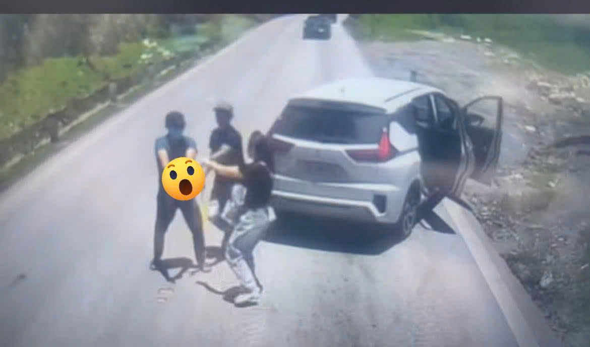 Người phụ nữ đi cùng can ngăn hành vi giơ vật giống súng của người đàn ông trên quốc lộ 6, đoạn qua đèo Đá Trắng. Ảnh: cắt từ clip camera hành trình.