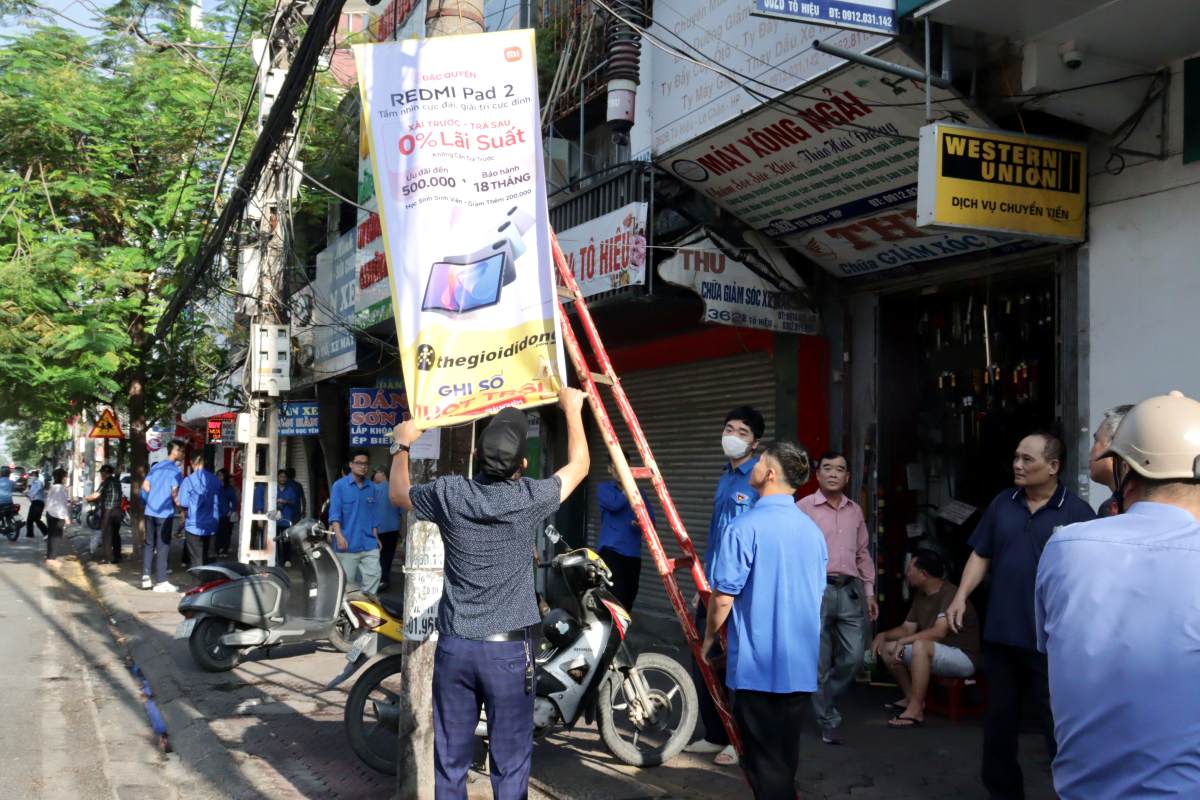 Can bo, nguoi dan tham gia don dep ve sinh moi truong, boc quang cao rao vat. Ảnh: Cong TTDT Hai Phong