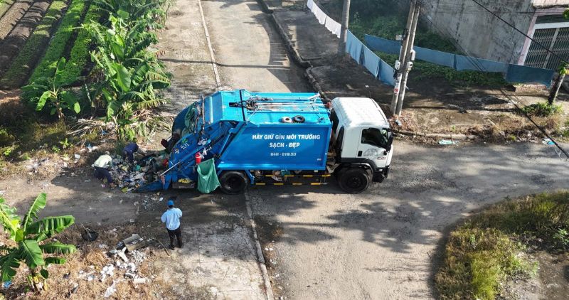 Des camions de dechets sont venus collecter le matin au point de rassemblement mais les dechets sont toujours en suspens car les groupes de collecte locaux les deversent toute la journee. Photo : Hoang Loc