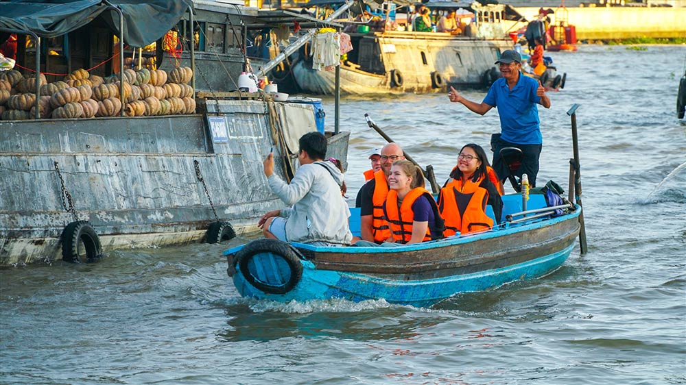 Los visitantes internacionales visitan CAI Rang Floating Market. Foto: Ta Quang