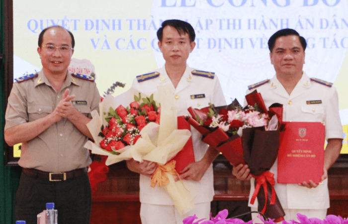 법무부 민사 집행 관리국 대표가 결정서를 수여하고 손라성 민사 집행 국장 및 부국장에게 꽃다발을 전달하며 축하하고 있습니다. 사진: 지에우 안