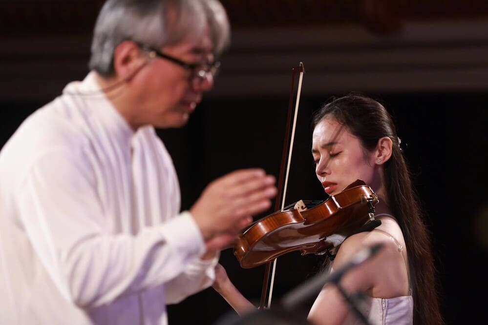 Nhac truong Honna Tetsuji va nghe si violin Hoang Ho Khanh Van. Anh: Ban to chuc