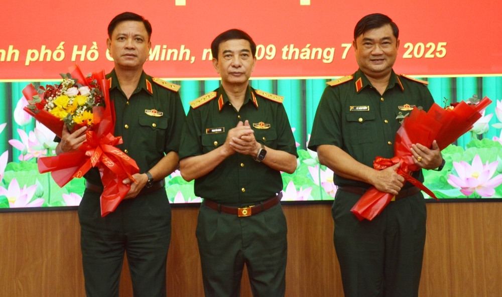 Phan Van Giang 대장이 Nguyen Truong Thang 육군 중장과 Le Xuan The 소장에게 꽃을 전달하며 축하하고 있습니다. 사진: 국방부