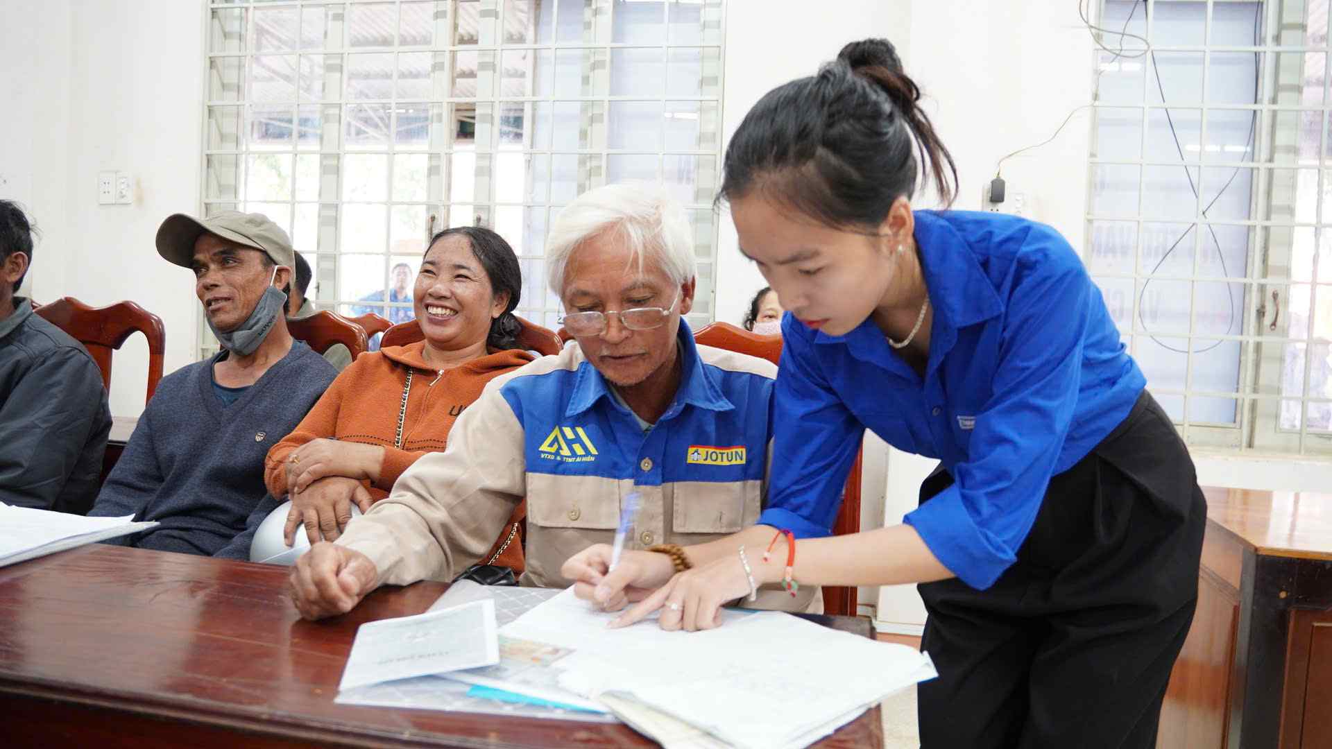 Les habitants de Dak Lak sont soutenus par une membre du syndicat pour resoudre les procedures administratives. Photo : Bao Trung
