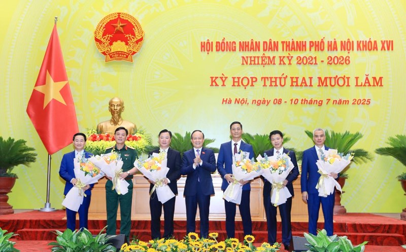 Chairman of the Hanoi People's Council Nguyen Ngoc Tuan presented flowers to congratulate the personnel who were elected to additional positions and take on new assignments. Photo: Hanoi.gov.vn