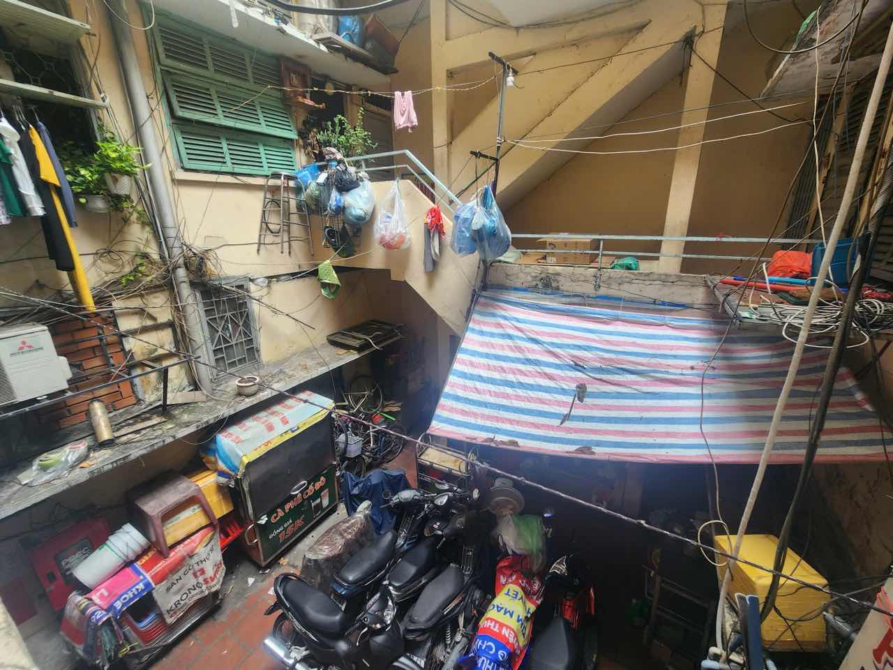  Loi thoat duy nhat tai chung cu cu 137 Ly Thuong Kiet (phuong Tan Son Nhat) bi bit kin boi xe va cac vat dung sinh hoat cua cu dan va he thong day dien chang chit. Anh: Anh Tu