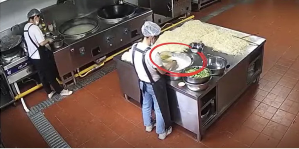 Nhan vien nha bep truong mau giao Boi Tin, tinh Cam Tuc, Trung Quoc them bot mau vao thuc pham. Anh: Cat tu video cua CCTV