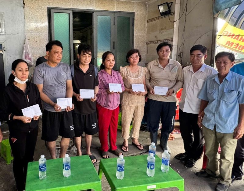 Sr. Pham Chi Tam - Vicepresidente de la Federacion de Trabajo de la Ciudad de Ho Chi Minh (segundo de la derecha) para dar regalos a los hogares de los trabajadores afectados por el incendio. Foto: Duc Long