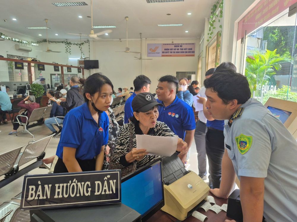 Cac tinh nguyen vien ho tro huong dan nguoi dan den giai quyet thu tuc hanh chinh tai phuong Binh Thanh. Anh: MTTQ Viet Nam phuong Binh Thanh