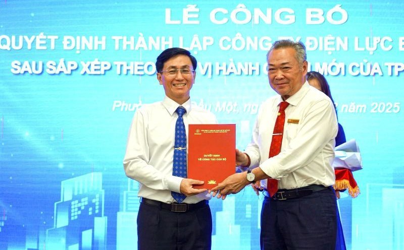 Mr. Pham Quoc Bao - Party Secretary, Chairman of the Board of Directors of EVNHCMC (right) - presented the decision to establish Binh Duong Power Company to Mr. Le Minh Quoc Viet - Director of Binh Duong Power Company. Photo: Duc Long