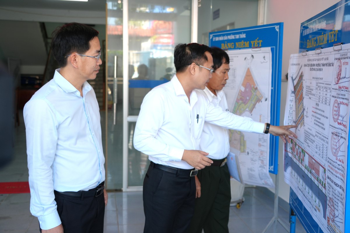 Los lideres del Comite Popular del barrio de Tam Thang explican las planificaciones recien anunciadas para que la gente las comprenda. Foto: Thanh An