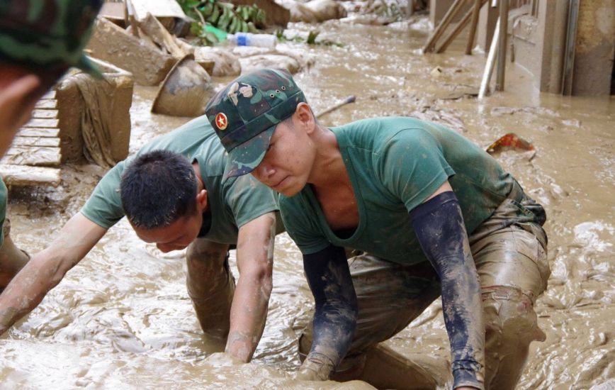Officers and soldiers of Military Region 4 help people in flooded areas of Nghe An overcome the consequences of floods. Photo: Hong Thai