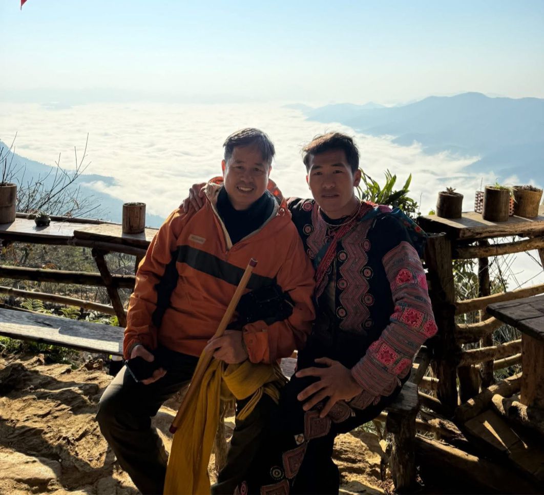 Chang trai H'Mong Giang A La (ben phai) chup anh cung du khach den voi Pa Co. Anh: Thu Hang
