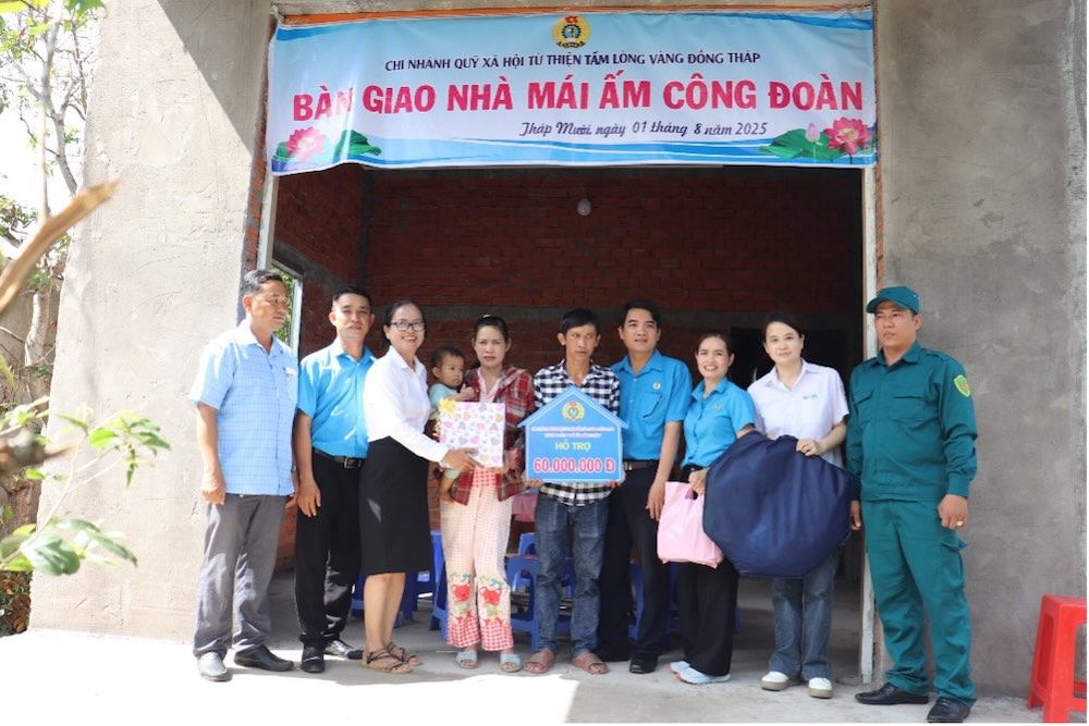 Cac dai bieu chup anh luu niem cung gia dinh doan vien tai le ban giao nha “Mai am Cong doan”. Anh: Luu Hung.