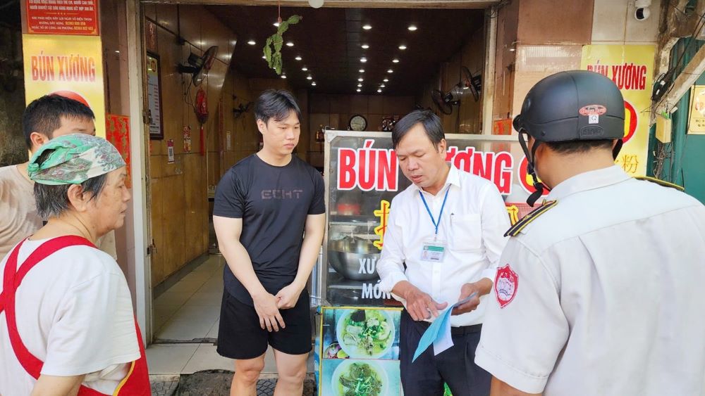 The inspection force of the Hai Chau Ward Public Service Supply Center reminded people about the regulation of not encroaching on sidewalks. Photo: Tran Thi