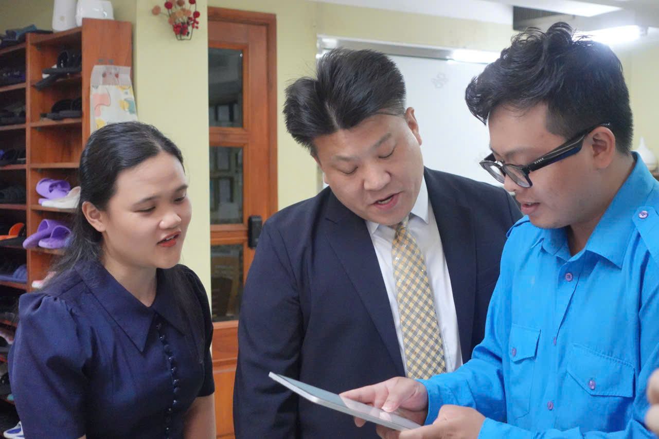 Can bo phuong Tan Hung truc tiep huong dan cho nguoi nuoc ngoai cach thao tac tro ly ao. Anh: Minh Tam