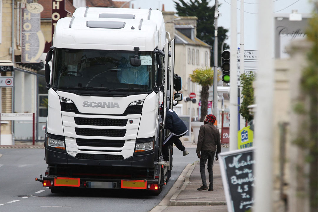Migrants jumped onto a truck in Ouistreham, near Caen, northwestern France, on October 5, 2017. Photo: AFP