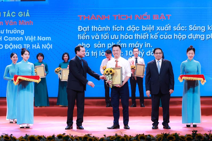 Le membre du Bureau politique le Premier ministre Pham Minh Chinh et le membre du Comite central du Parti le president de la Confederation generale du travail du Vietnam Nguyen Dinh Khang remettent des prix aux auteurs et groupes d'auteurs du programme '1 million d'initiatives' en 2023. Photo : Hai Nguyen