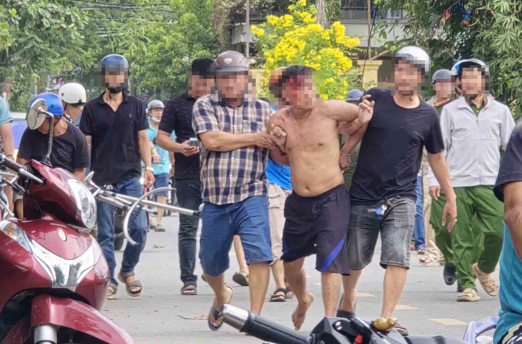  Người đàn ông bị lực lượng chức năng khống chế, đưa về trụ sở công an làm việc. Ảnh: Nguyên Chân
