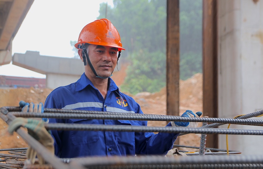 Workers overcome the sun and rain to construct the expansion of the La Son - Hoa Lien expressway.