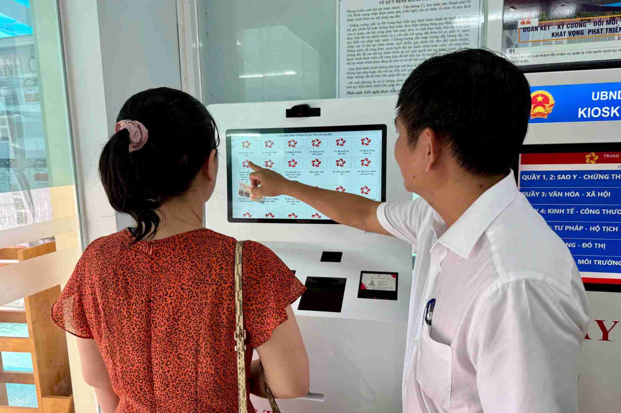 Mr. Nguyen Minh Thien - Vice Chairman of Tan Hung Ward People's Committee - instructed people to use kiosks to automatically fill in information and print forms. Photo: Minh Tam