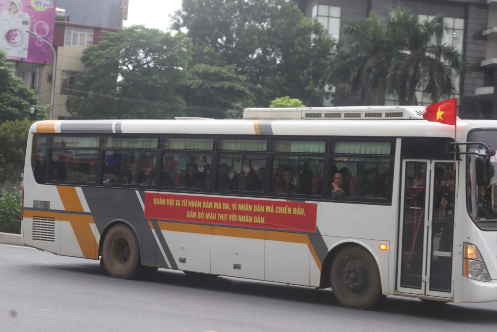 Xe mang dong chu “Quan doi ta tu nhan dan ma ra, vi nhan dan ma chien dau, gan bo mau thit voi nhan dan“. Tren xe, cac can bo chien si vay tay chao nguoi dan ben duong. Anh: Pham Dong