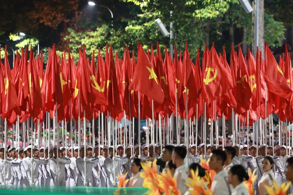 Khoi co Dang, co To quoc tien vao le dai. Nhung la co Dang, co To quoc tung bay, tuong trung cho ly tuong, niem tin chien thang; ban linh, tri tue lanh dao cua Dang Cong san Viet Nam; suc manh cua khoi dai doan ket toan dan toc, duoc khoi nguon, boi dap tu lich su, bung chay cho hom nay va toa sang den mai sau. Anh: Hai Nguyen