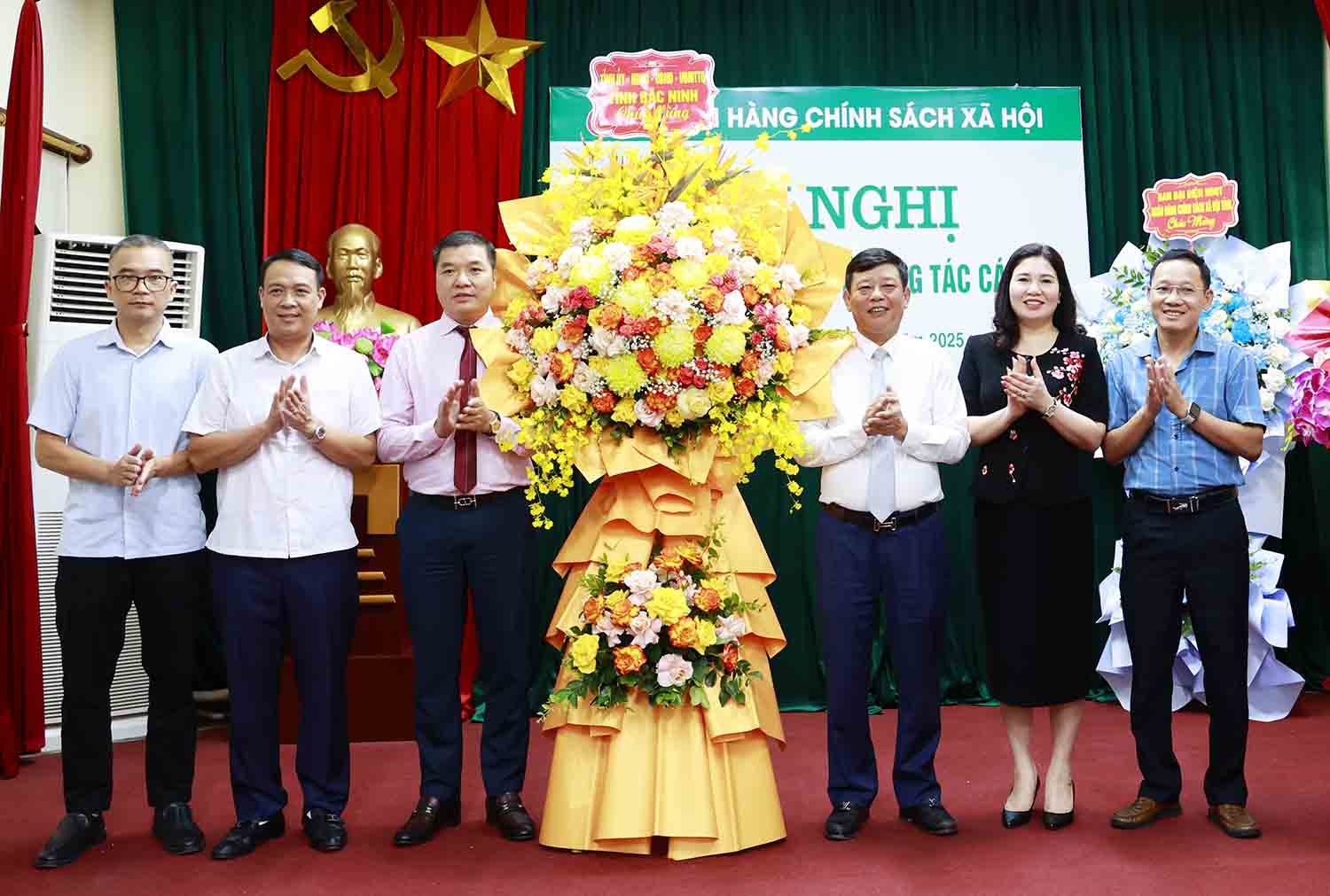 대표들이 Do Van Hien 씨(왼쪽에서 세 번째)가 박닌성 CSXH 은행 지점장으로 임명된 것을 축하하며 꽃을 전달하고 있습니다. 사진: Duong Thuy