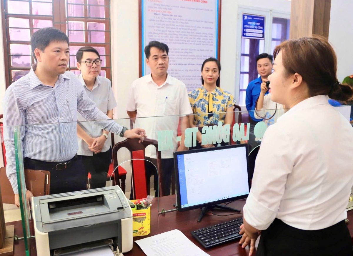 Vice Chairman of the City People's Committee Hoang Minh Cuong discussed with the officer receiving the dossier at the Chi Linh Ward Public Administration Service Center. Photo: Hai Phong Portal