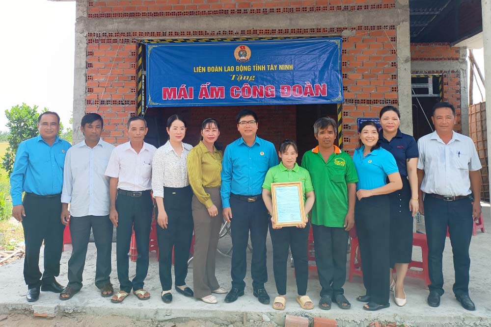 Tay Ninh 지방 노동 연맹 부위원장 Nguyen Hoai Thanh은 조합원 Le Thi Diem에게 '노동조합의 따뜻한 집'을 인도하는 결정을 수여했습니다. 사진: My Hanh