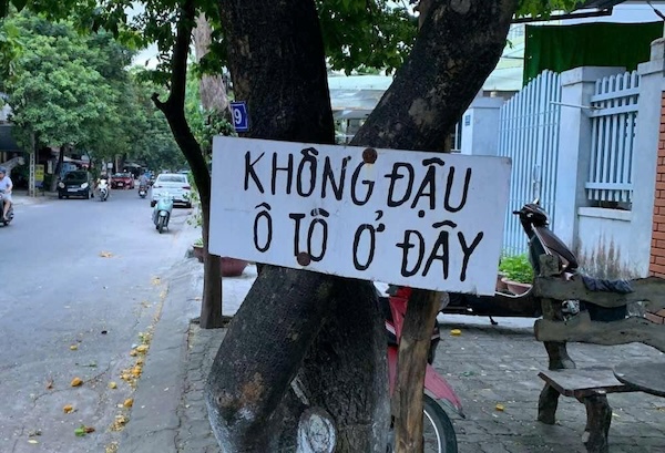 Mot gia dinh tai duong Nguyen Xi con treo ca bien “khong dau o to o day” ngay truoc cua nha de nhac nho. Anh: Thanh Huyen.