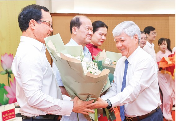 정치국 위원 당 중앙위원회 서기 베트남 조국전선 중앙위원회 위원장 Do Van Chien이 당 중앙위원회 위원 베트남 조국전선 중앙위원회 부위원장 베트남 노동총연맹 위원장 Nguyen Dinh Khang에게 꽃다발을 전달하고 축하하고 있습니다. 사진: HAI NGUYEN