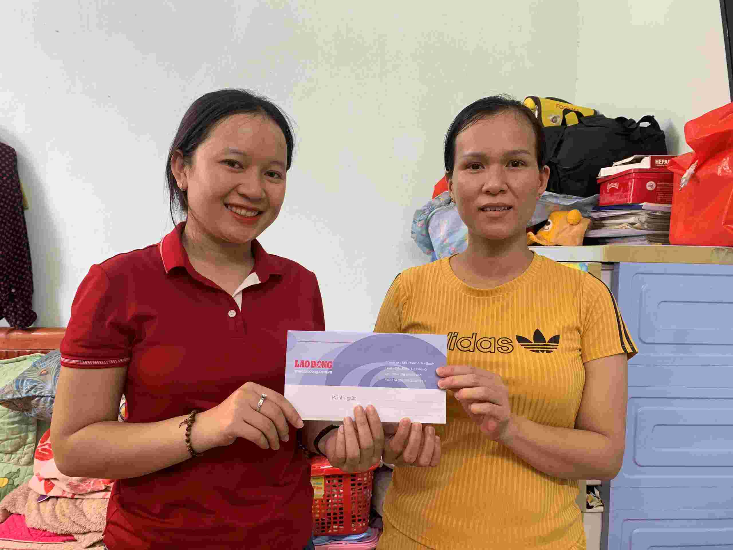 Phong vien Nguyen Linh (ben trai) thay mat Quy Xa hoi tu thien Tam long Vang trao tan tay chi Vo Thi My Le so tien 7.925.000 dong. Anh: MY LINH