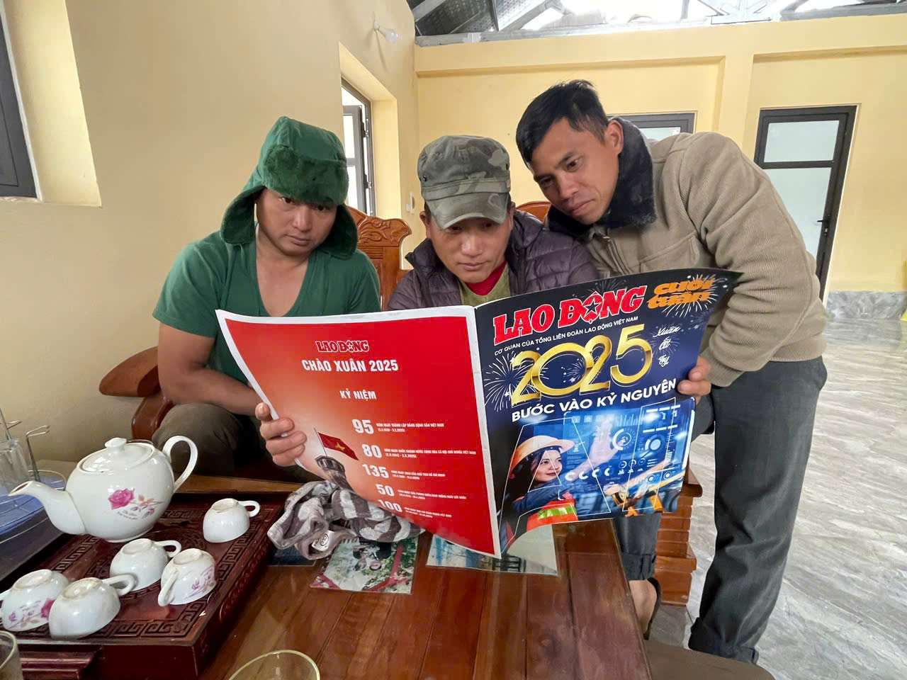 Sung A Kenh（青いシャツ）、Ly Seo Khanh氏（真ん中）は、労働新聞を注意深く見ました。写真：ダイロング