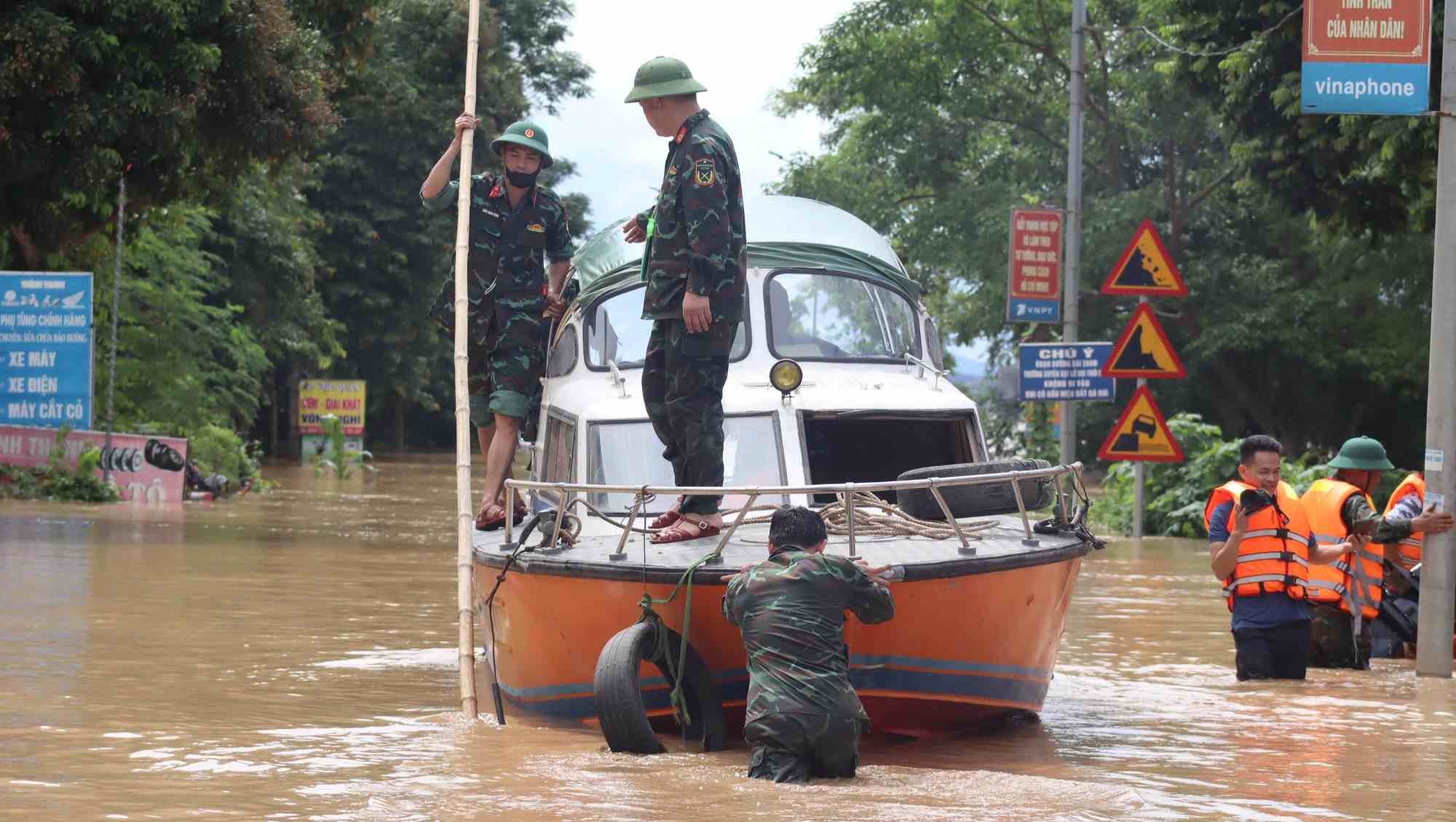 Reporter Tran Tuan - Lao Dong Newspaper (photo camera) was working on flood work on National Highway 7 in Con Cuong Commune, when the authorities had banned the road. Photo: D'C LAM