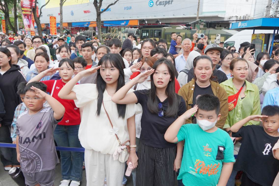 Dai bieu va nguoi dan thuc hien nghi thuc chao co. Anh: Ta Quang