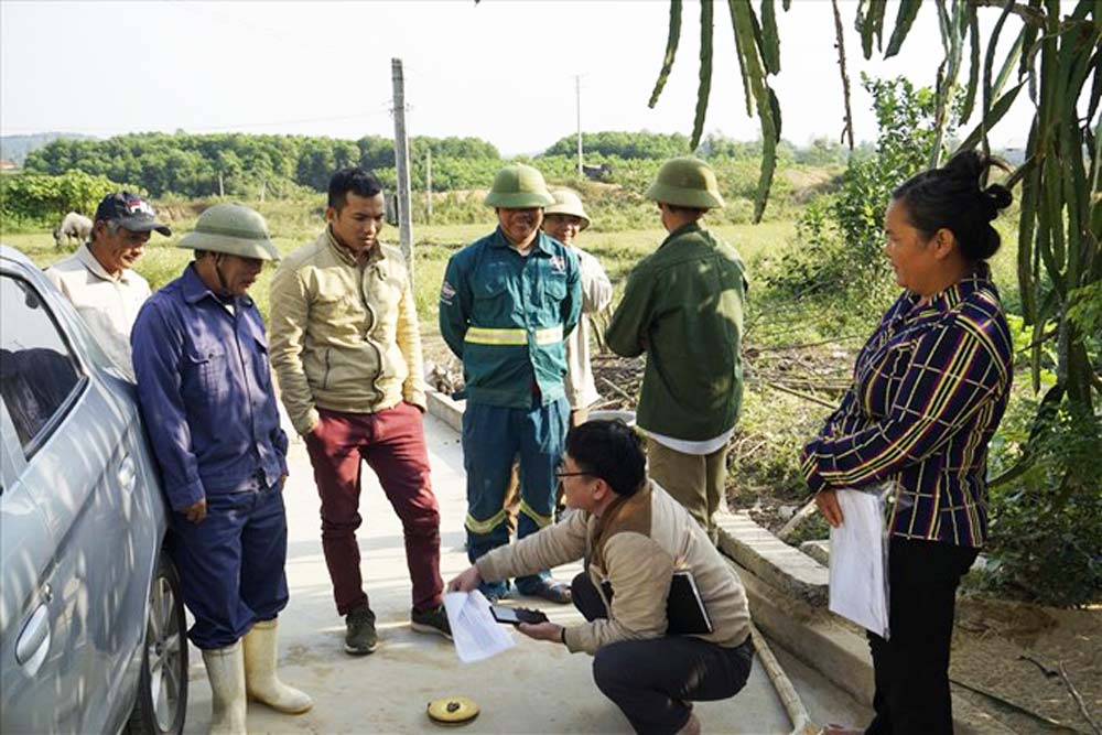 Phong vien Quang Dai (nguoi ngoi) trao doi voi nguoi dan trong mot lan tac nghiep tai thi xa Hoang Mai - Nghe An. Anh: HT