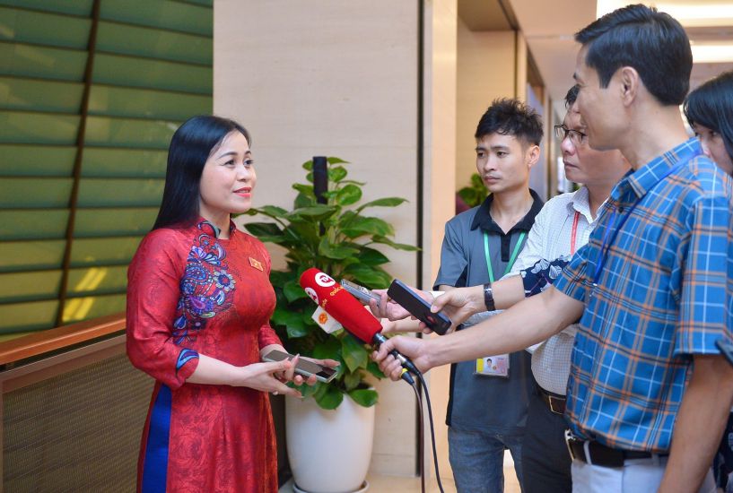 Reporter Pham Dong (3rd from right) interviewed National Assembly delegates in the hallway. Photo: Tue Linh