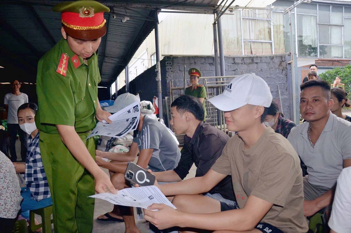 흥하사 공안은 노동자들에게 온라인 사기 식별 및 예방 징후를 홍보하는 안내서를 배포합니다. 사진: 흥옌성 공안