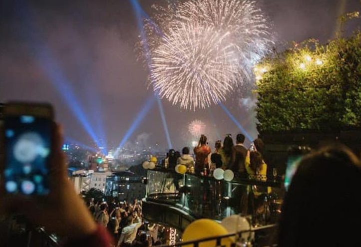 Khach xem phao hoa tai mot quan bar o trung tam pho co Ha Noi. Anh: Estrella Skybar