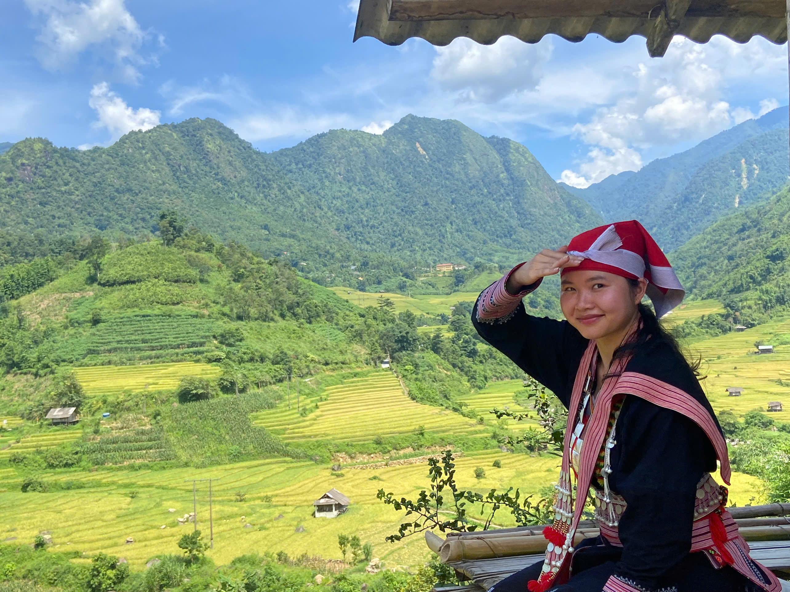 Nữ du khách diện trang phục của người Dao Đỏ chụp ảnh check-in.