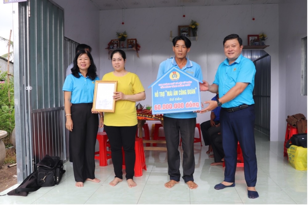 Ba Huynh Thi Tuyet Vui va ong Nguyen Thanh Nhan trao quyet dinh va bang tuong trung cho doan vien Tran Thuy Kieu. Anh: Luu Hung. 
