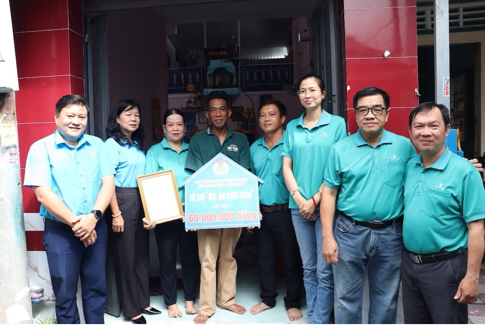 Lanh dao LDLD tinh Dong Thap, bo phan Cong doan cac khu cong nghiep, CDCS Cong ty TNHH Co May Sa Dec chup anh luu niem cung gia dinh doan vien Kim Phuong. Anh: Luu Hung. 