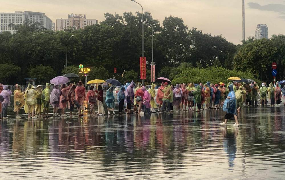 Despite the heavy rain, hundreds of spectators still patiently waited for the ticket checking time. Photo: Huyen Linh