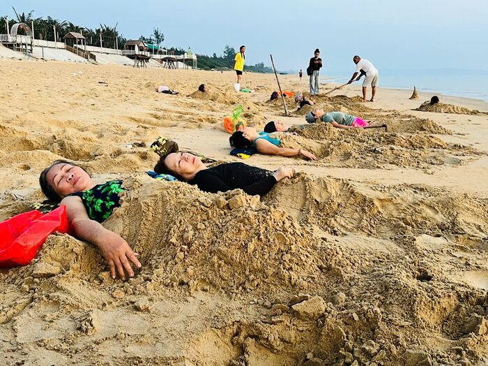Many people in Quang Ngai believe that the habit of burying themselves in sand in the early morning can help their bone and joint diseases subside. Photo: Ai Vy