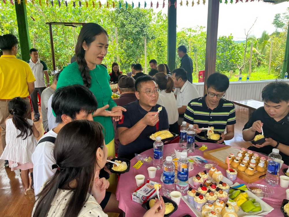 Bi thu Dang uy xa Ea Knuec Ngo Thi Minh Trinh gioi thieu, moi doan khach thuong thuc sau rieng va cac san pham lam tu sau rieng cua xa. Anh: Chi Long
